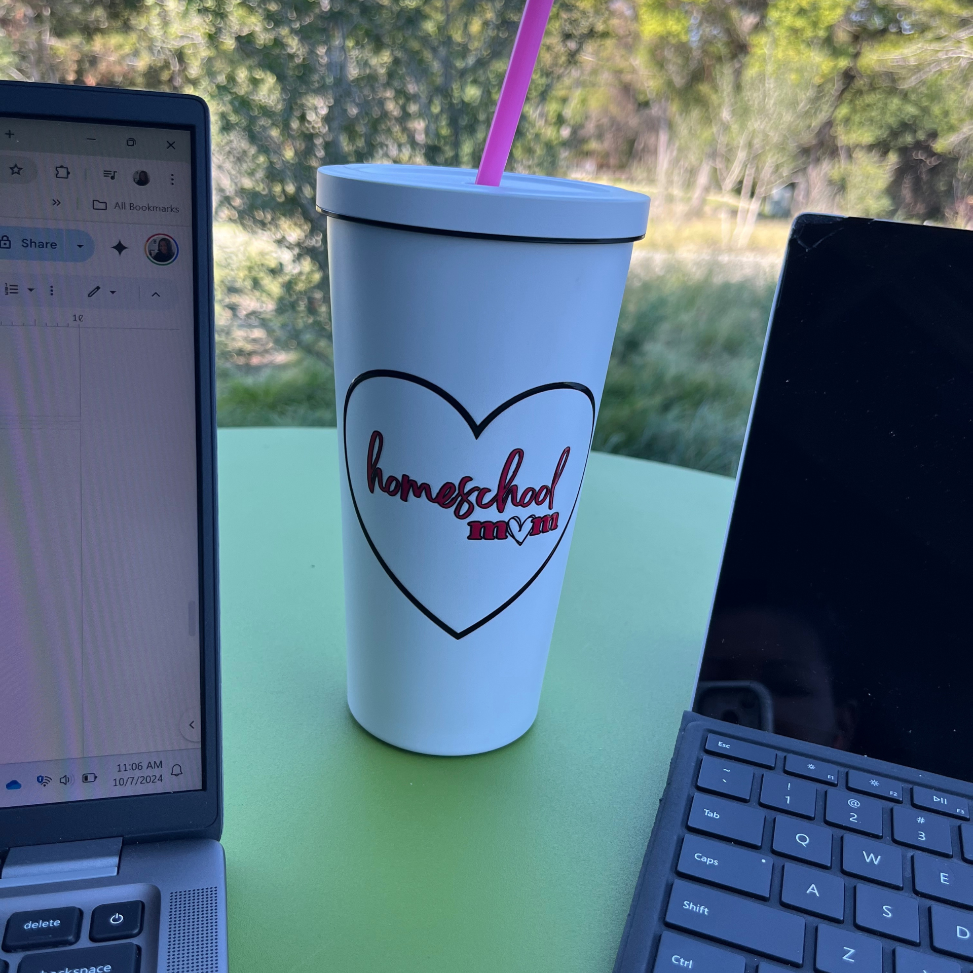 Cup with text, "Homeschool," two computers sitting on an outdoor table